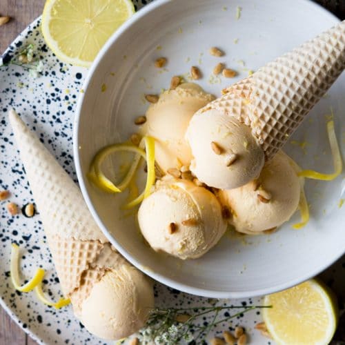 lemon ice cream scoops in a bowl garnished with lemon zest