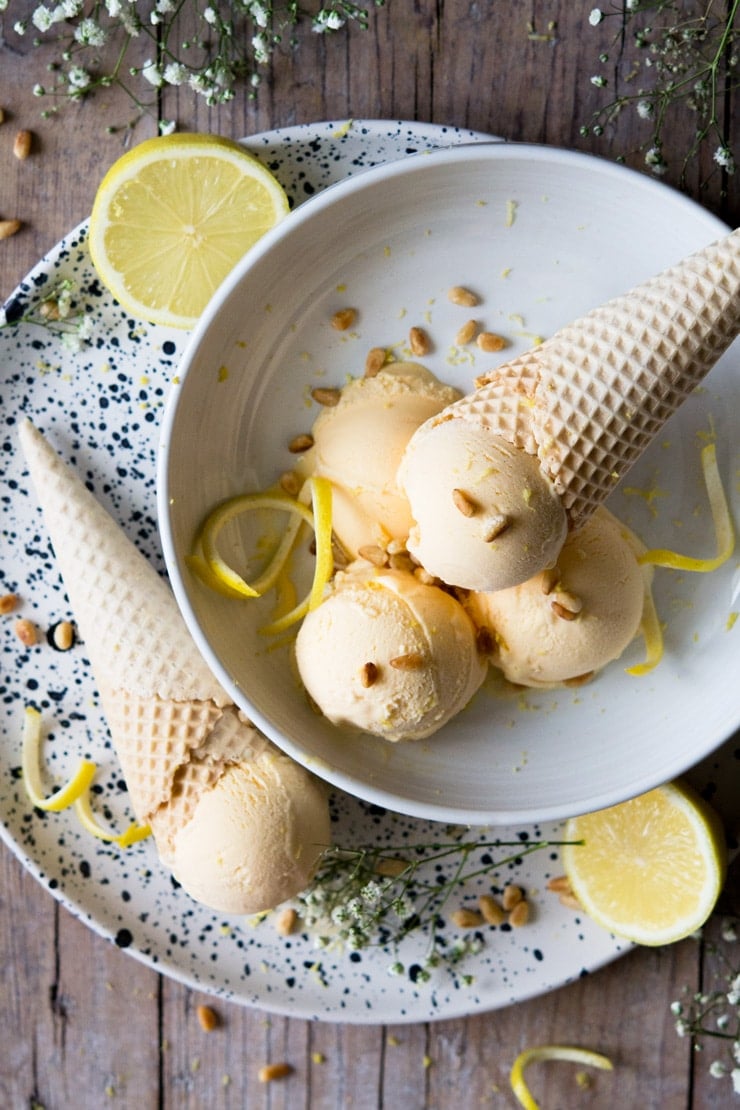 lemon ice cream scoops in a bowl garnished with lemon zest