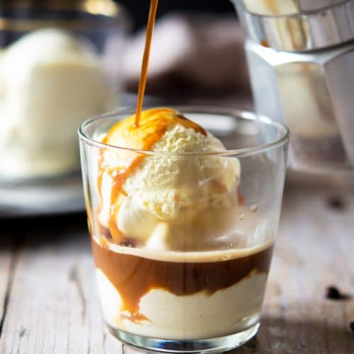 A photo of coffee getting poured over ice cream in a glass to make an affogato