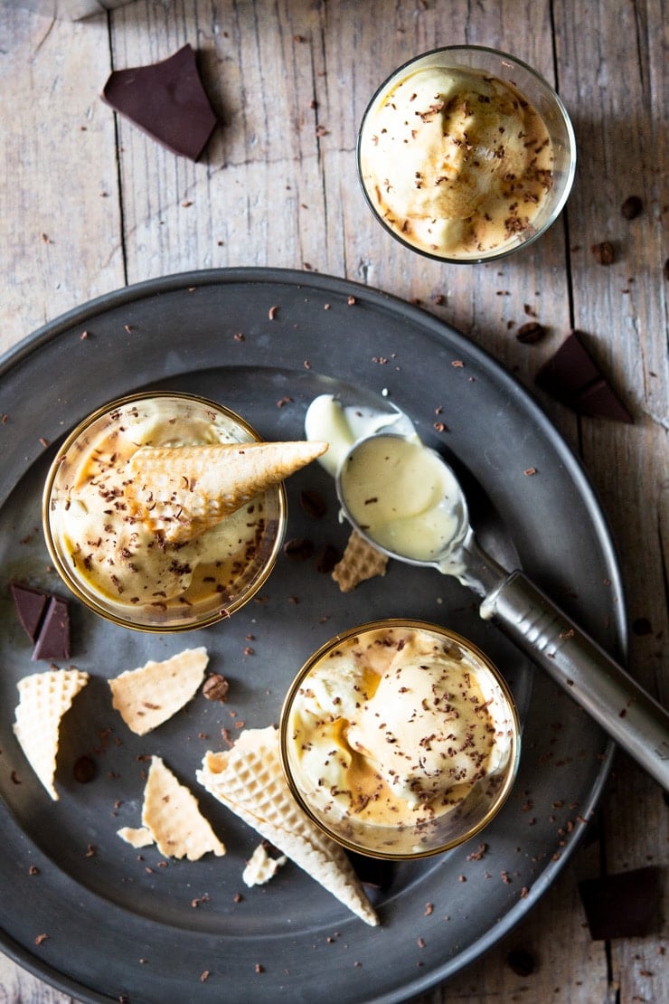 An overhead shot of two affogato desserts in glasses with ice cream cones broken up around them