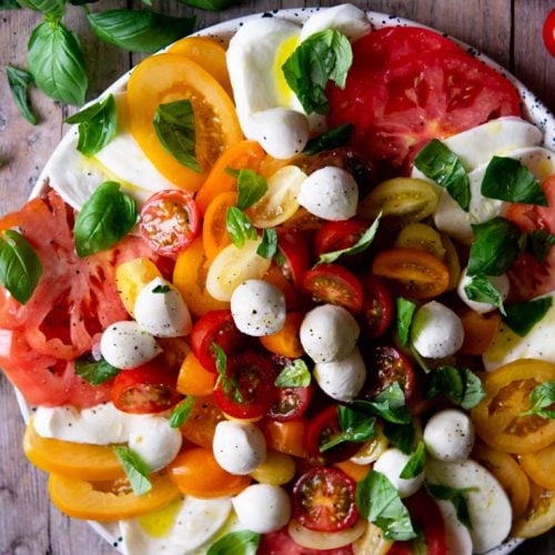An overhead shot of a caprese salad with vibrant coloured tomatoes