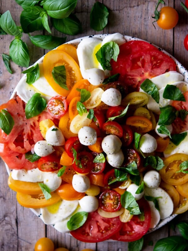 An overhead shot of a caprese salad with vibrant coloured tomatoes