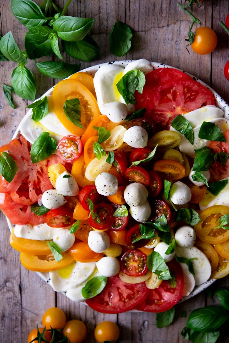 An overhead shot of a caprese salad with vibrant coloured tomatoes