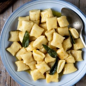A square image of gnocchi with brown butter sage sauce