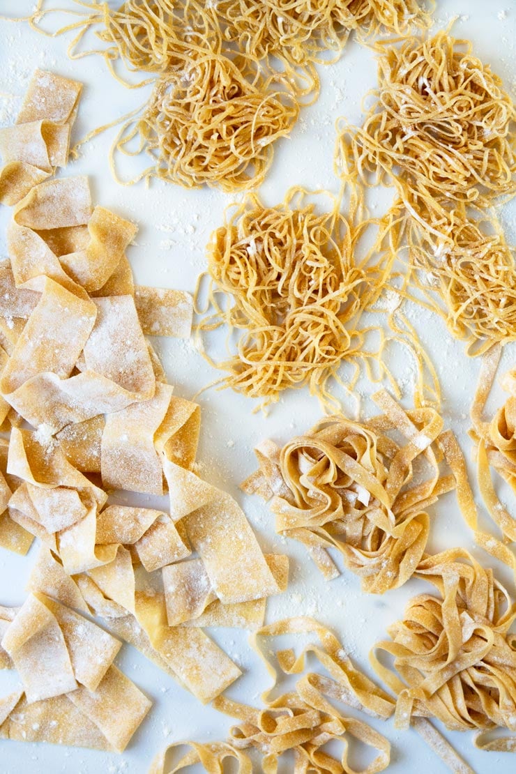 An overhead shot of different fresh pasta shapes made with homemade pasta dough