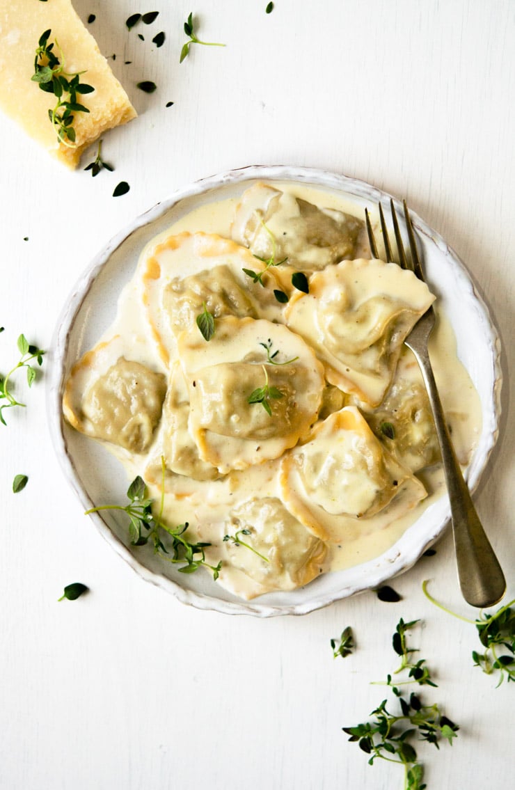 Overhead View of Mushroom Stuffed Ravioli on a White Plate with a Fork