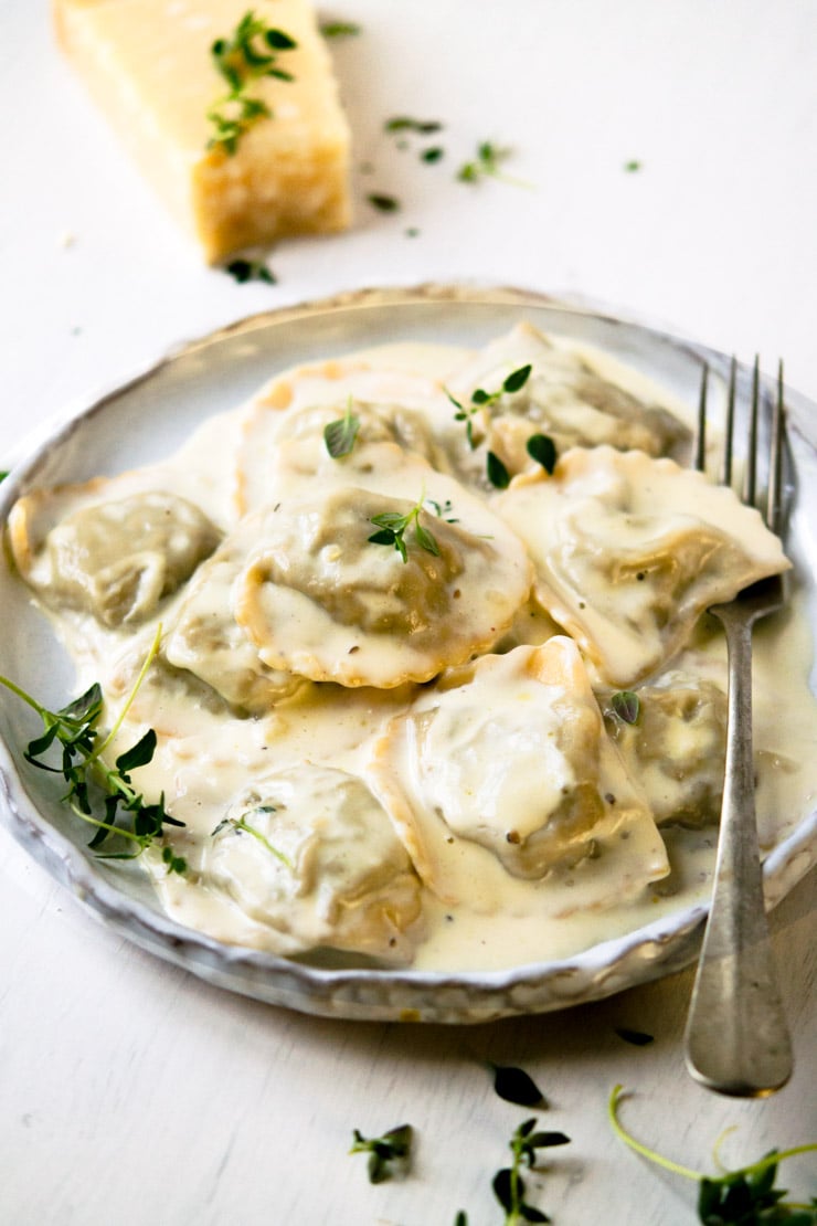 Close-up view of Stuffed Mushroom Ravioli with Parmesan Cheese on a Plate with a Fork