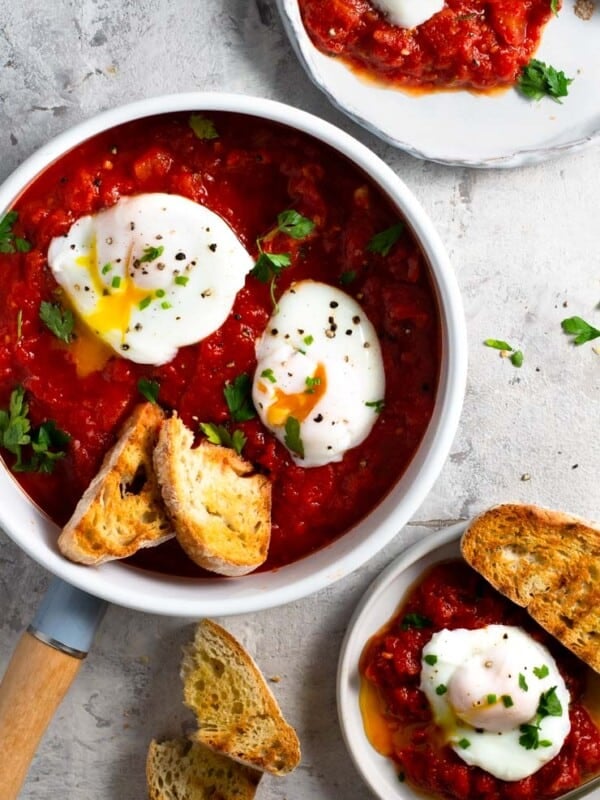 Eggs in purgatory in a frying pan with crusty bread at the side