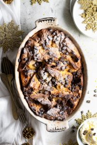 A panettone bread pudding in a baking dish with a dusting of powdered sugar