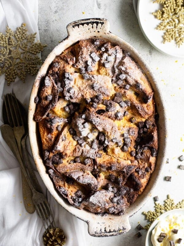 A panettone bread pudding in a baking dish with a dusting of powdered sugar