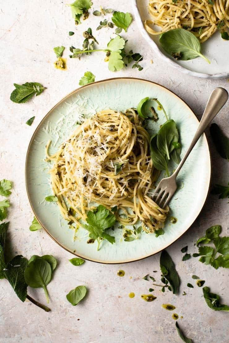 An overhead shot of spaghetti with garlic butter pasta sauce and herbs