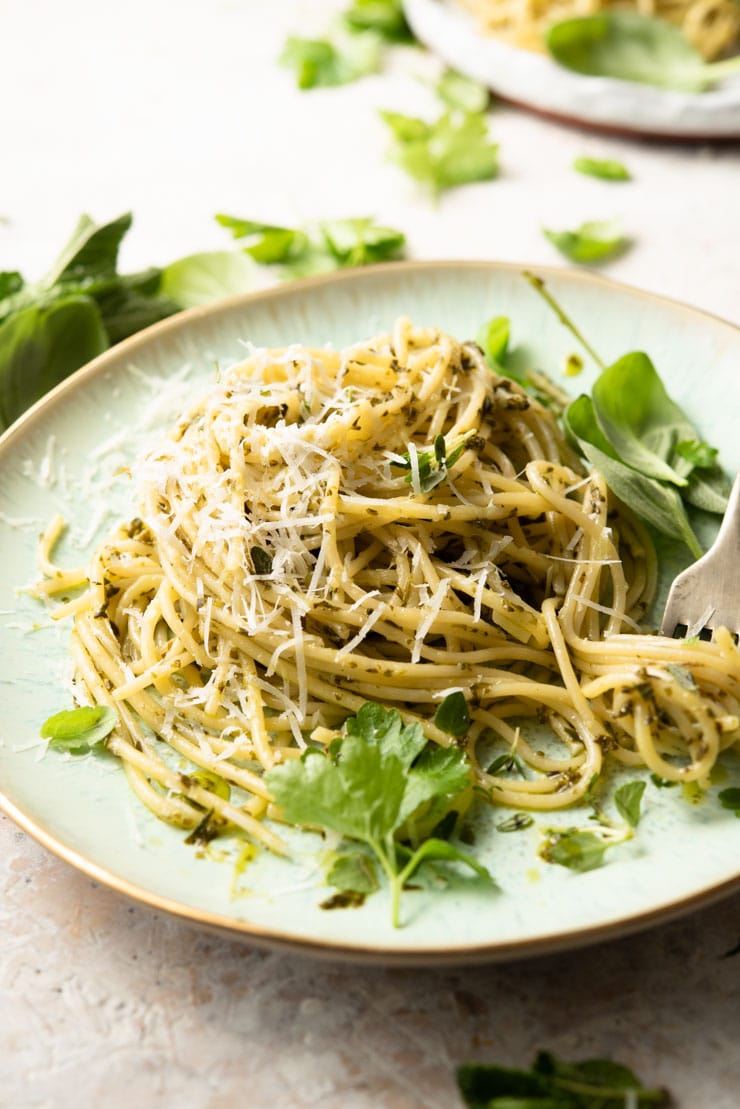 A side shot of spaghetti with garlic butter pasta sauce and herbs