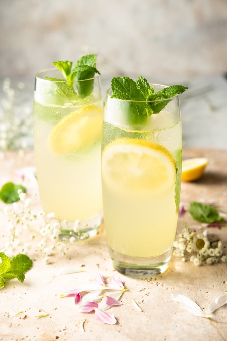 Two limoncello mojito cocktails garnished with mint and lemon