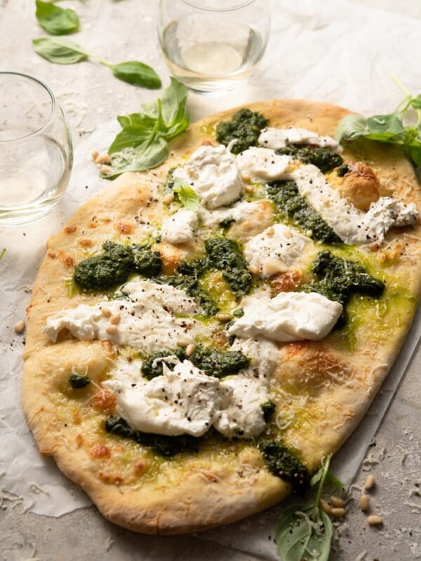 A side shot of a basil pizza with burrata