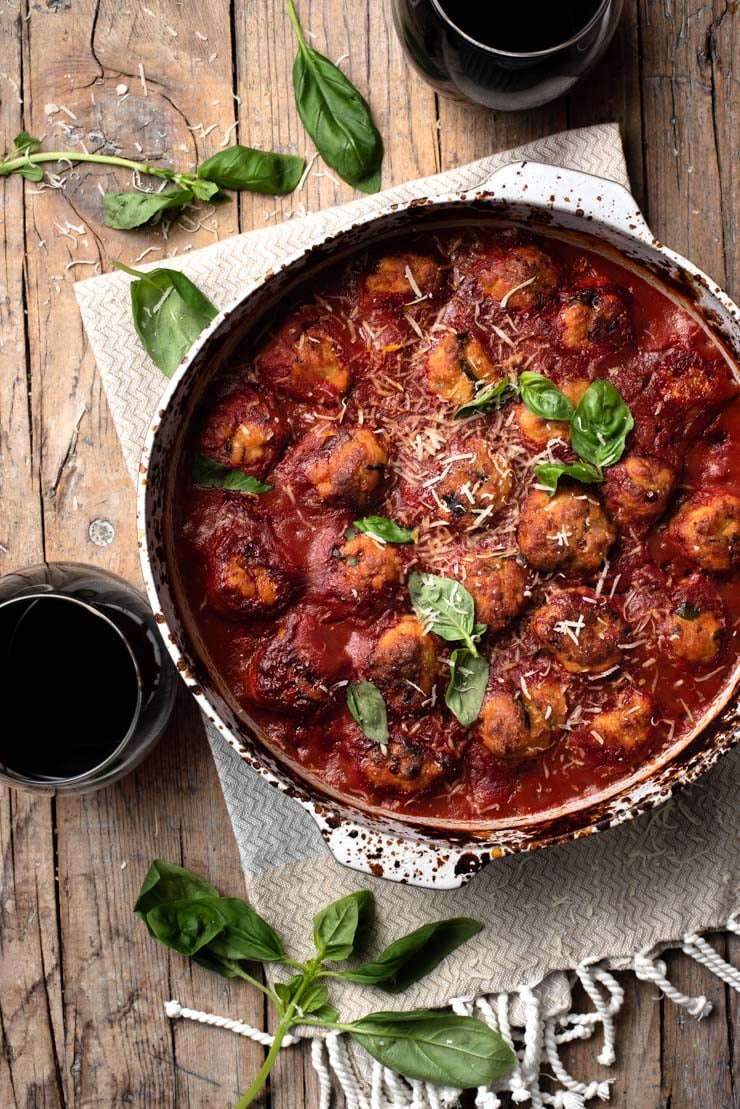 An overhead shot of baked chicken meatballs in a casserole dish