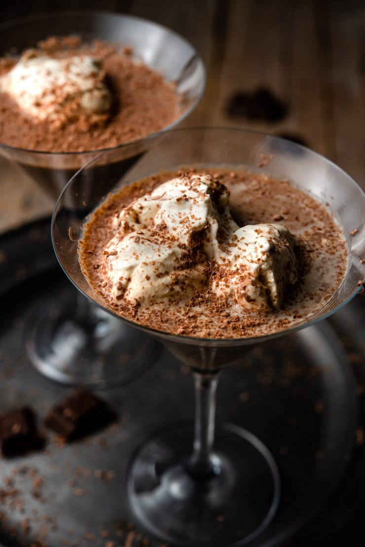 A close up of a chocolate martini topped with whipped cream and chocolate shavings