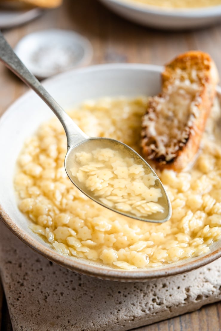 A close up of a spoonful of pastina soup