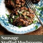 A pinterest graphic for sausage stuffed mushrooms on a blue and white plate.