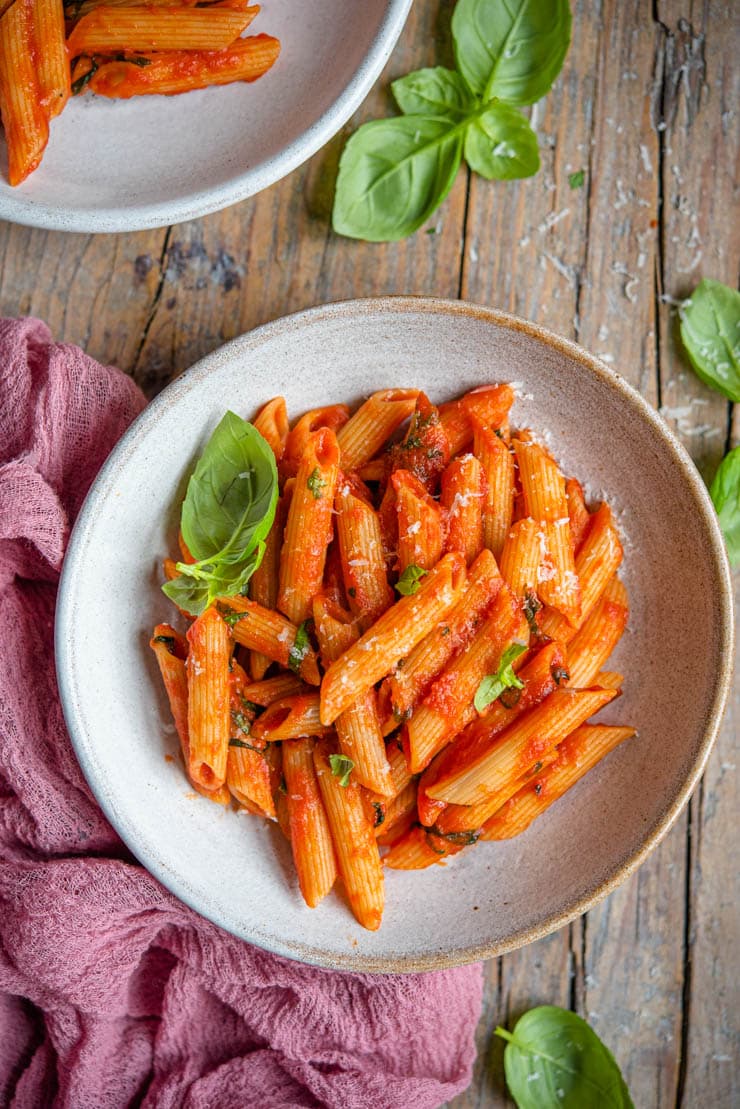 An overhead shot of tomato pasta in a bowl with basil