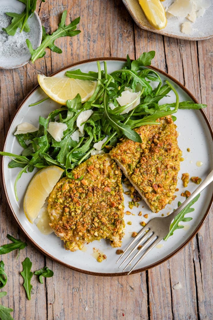 Pistachio chicken on a plate with arugula and parmesan