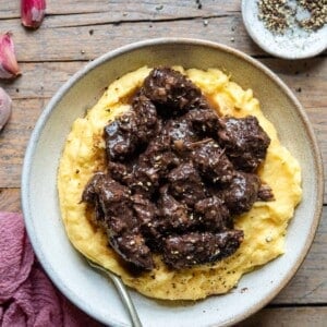 An overhead shot of an Italian beef stew on top of a bowl of polenta.