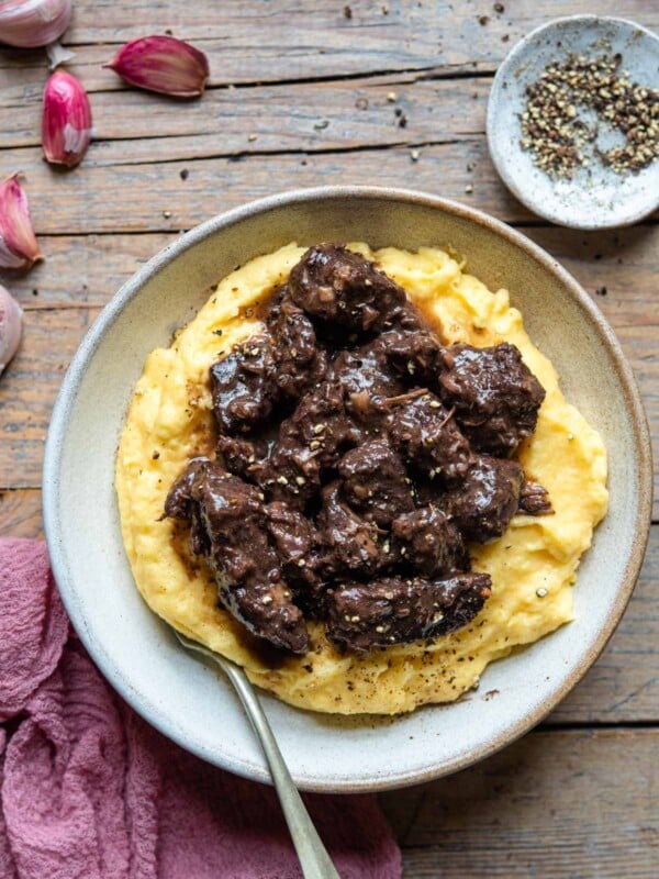An overhead shot of an Italian beef stew on top of a bowl of polenta.