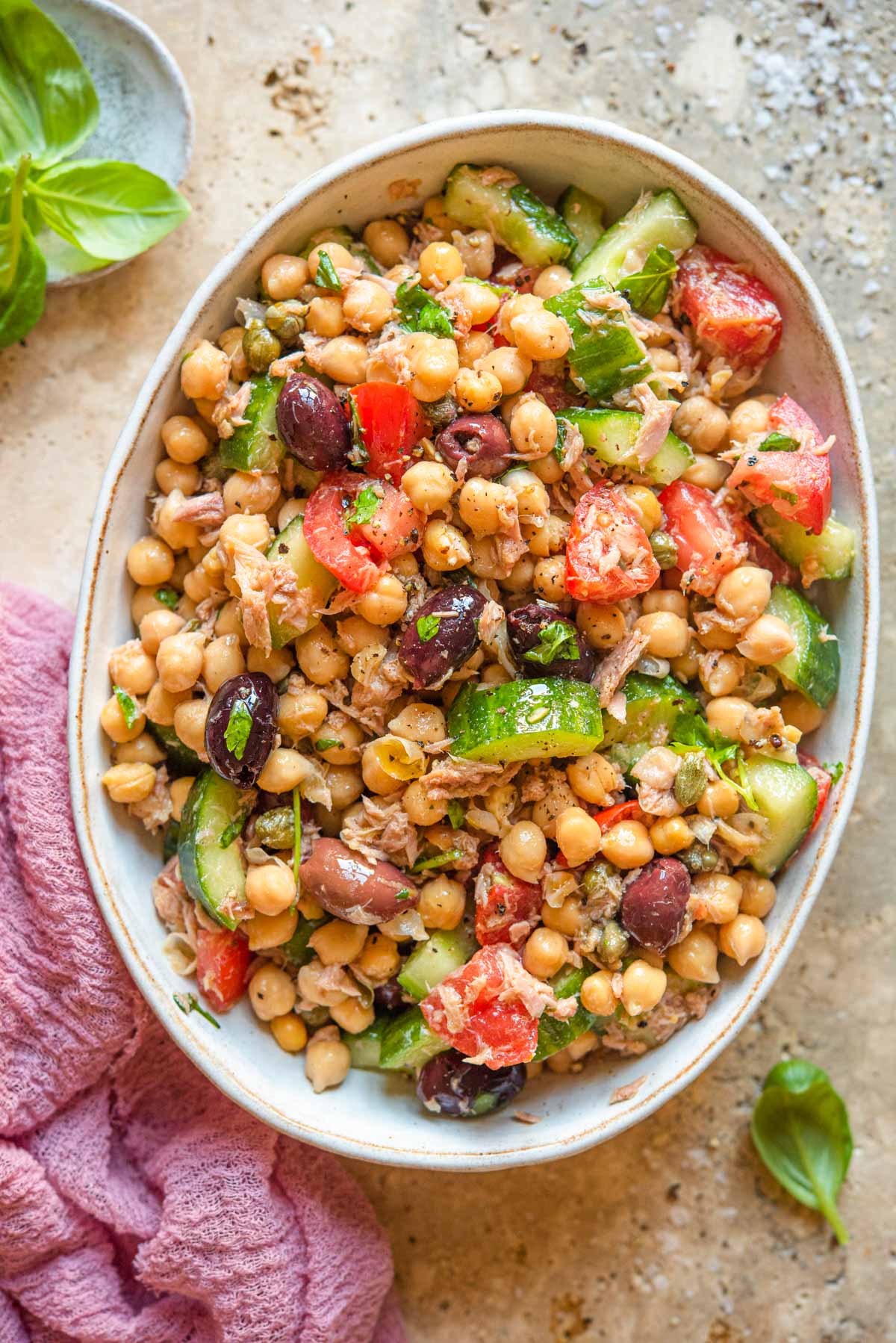 An overhead shot of a salad with chickpeas, tuna and tomatoes in a large bowl