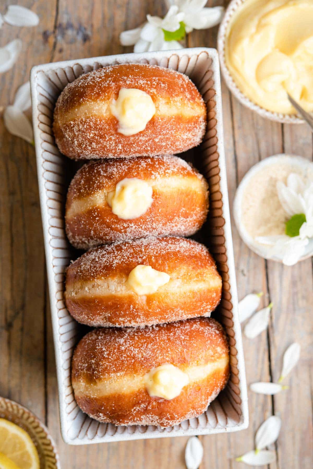 An overhead shot of bomboloni doughnuts in a rustic dish