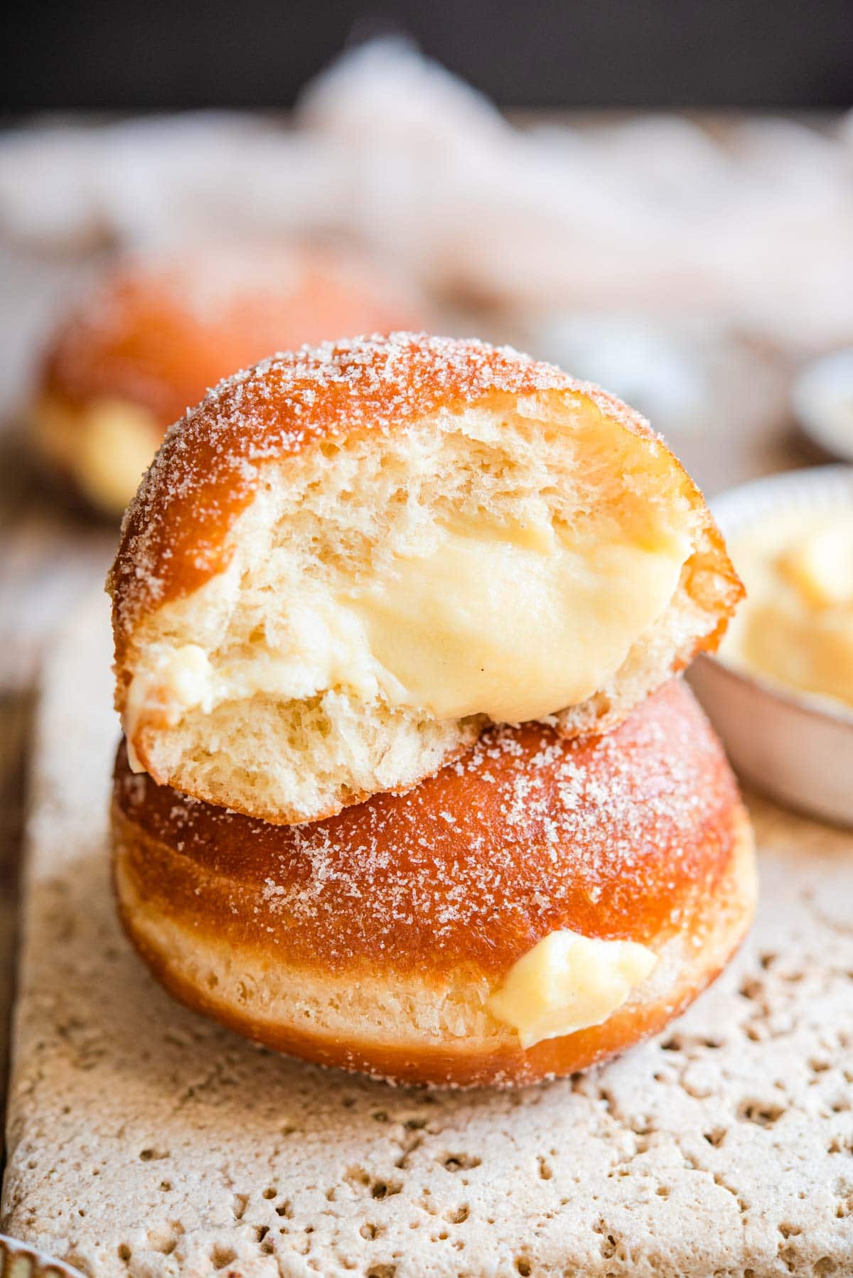 Two doughnuts stacked on top of each other with one cut in half