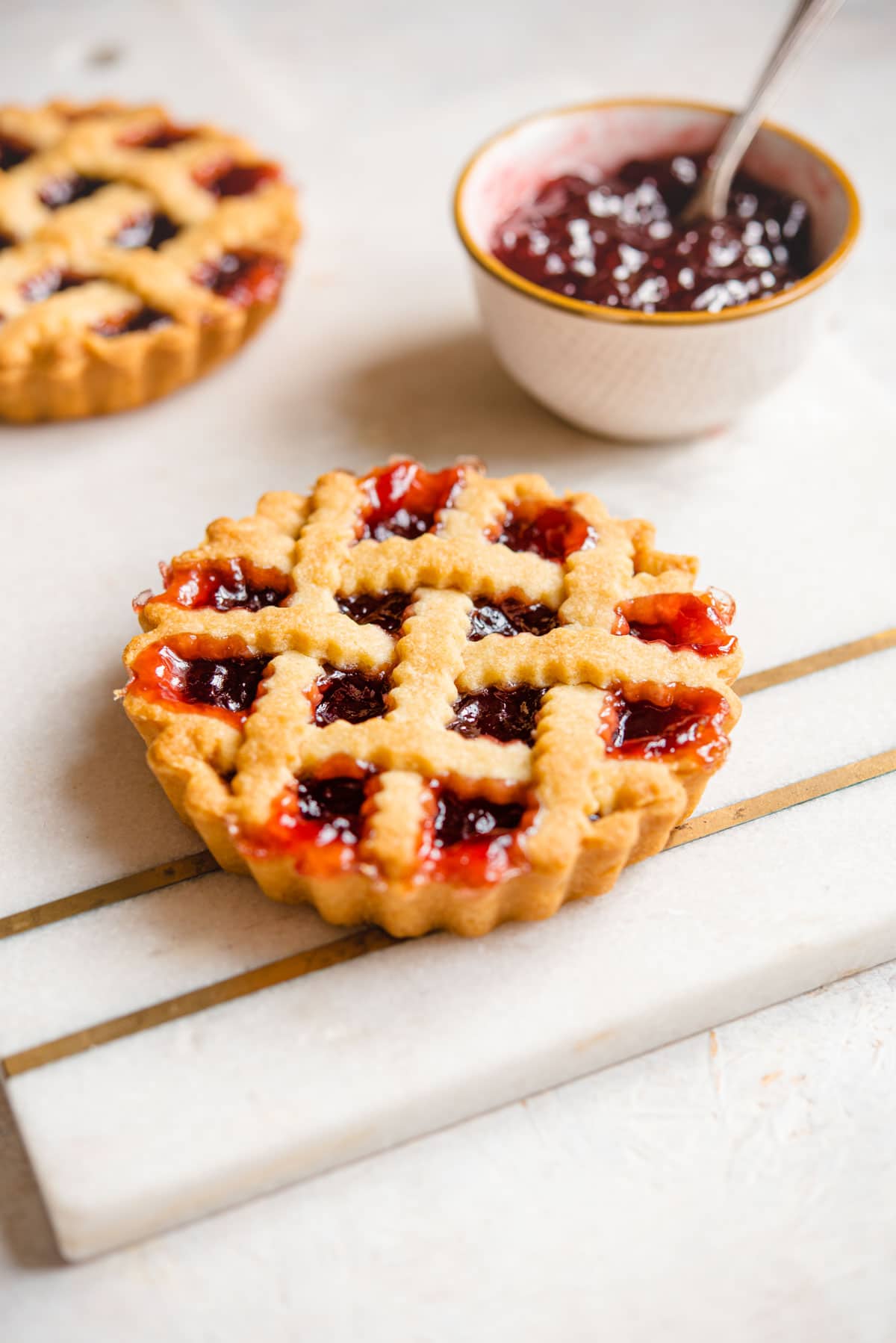 A mini Italian jam tart on a marble cutting board