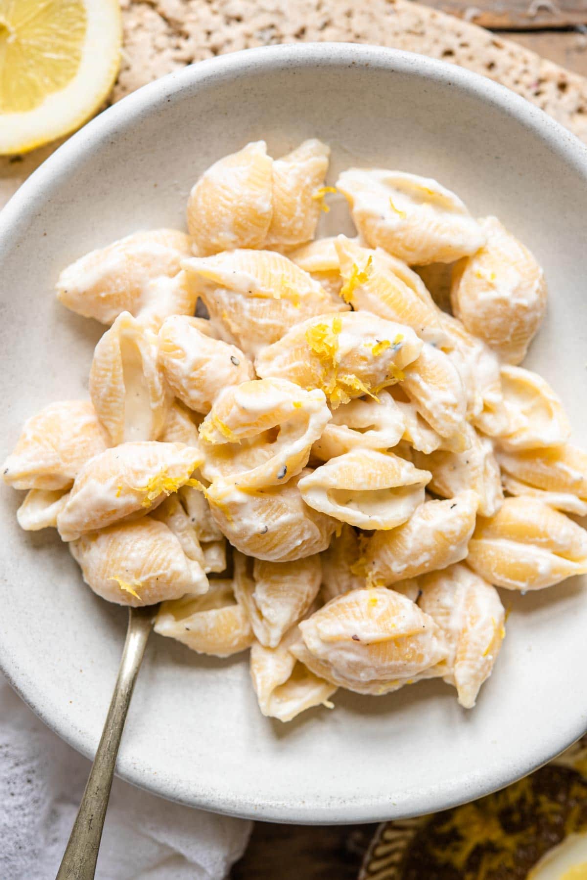 An overhead shot of ricotta lemon pasta in a bowl with fresh lemon zest