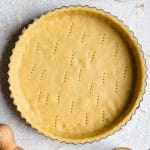 A square photo of raw sweet shortcrust pastry in a tart case