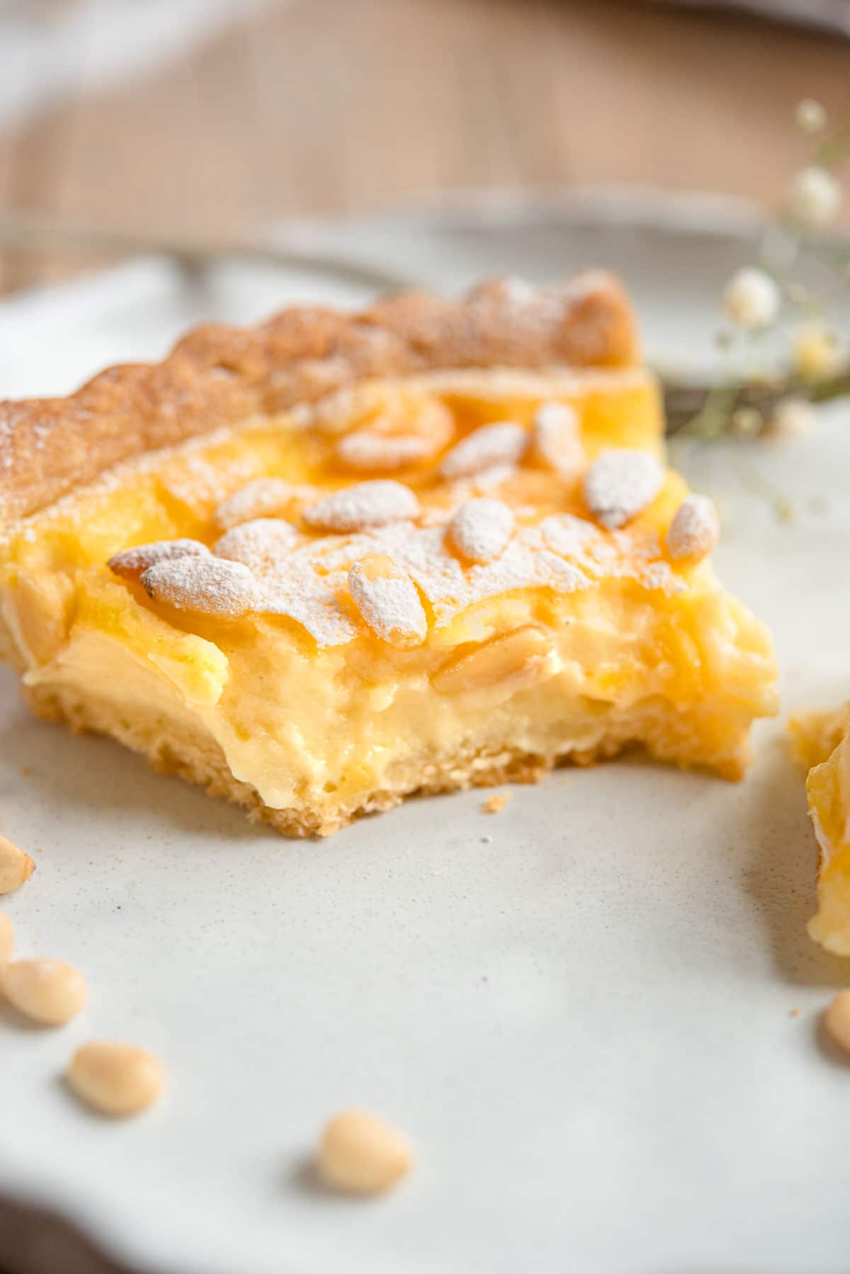 A close up of a slice of torta della nonna with a bite out