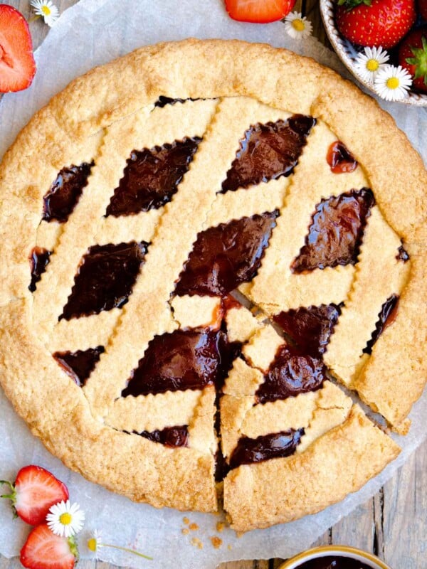 An overhead shot of an Italian crostata with strawberries around it