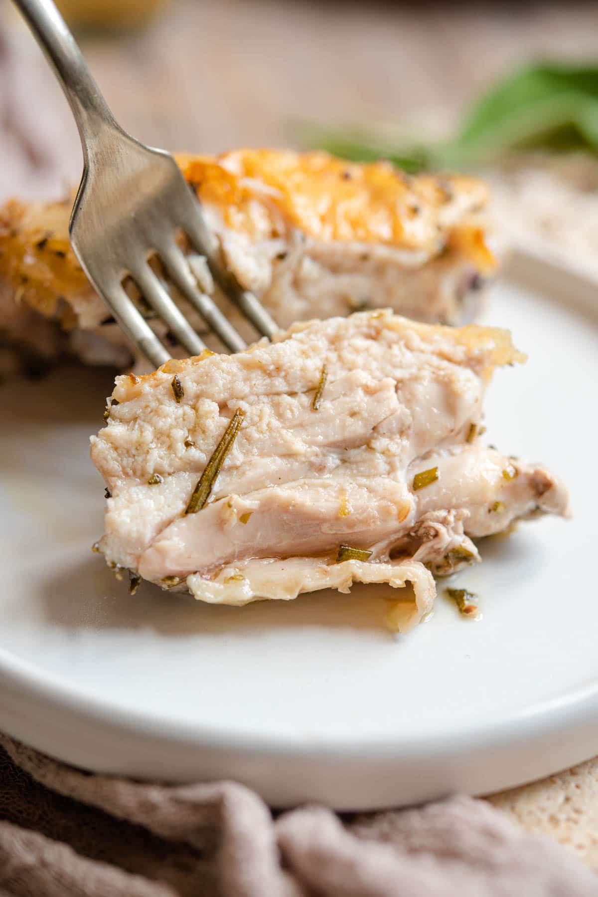 A close up of a juicy piece of chicken on a fork