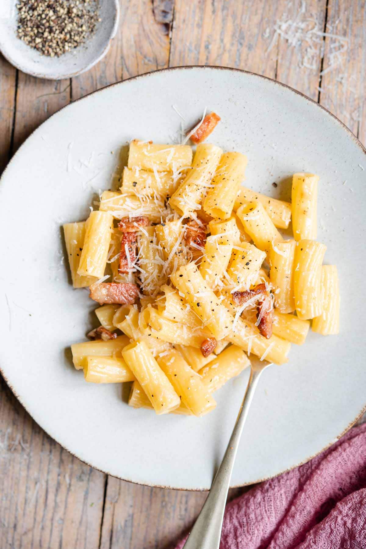 An overhead shot of rigatoni pasta with guanciale on a plate