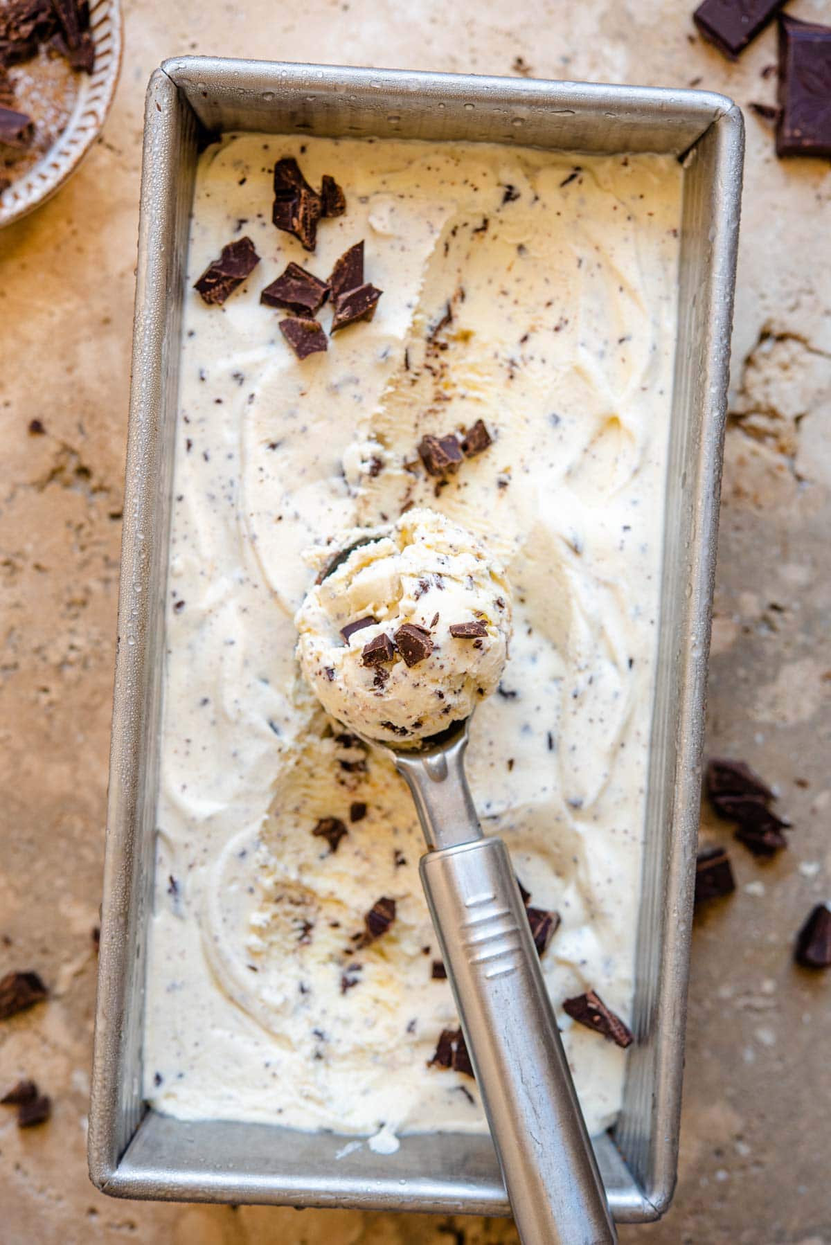 An overhead shot of a tub of ice cream with a scoop inside