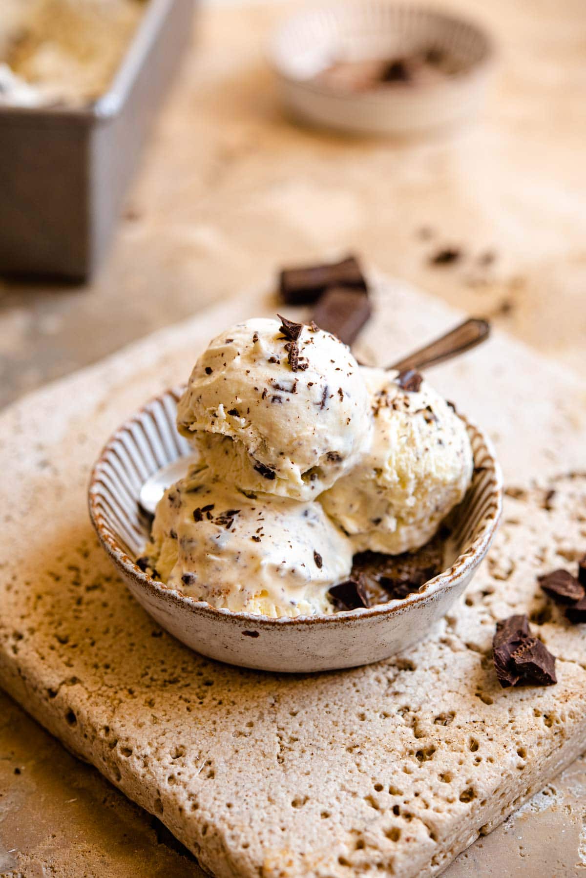 A close up of three scoops of ice cream in a rustic dish