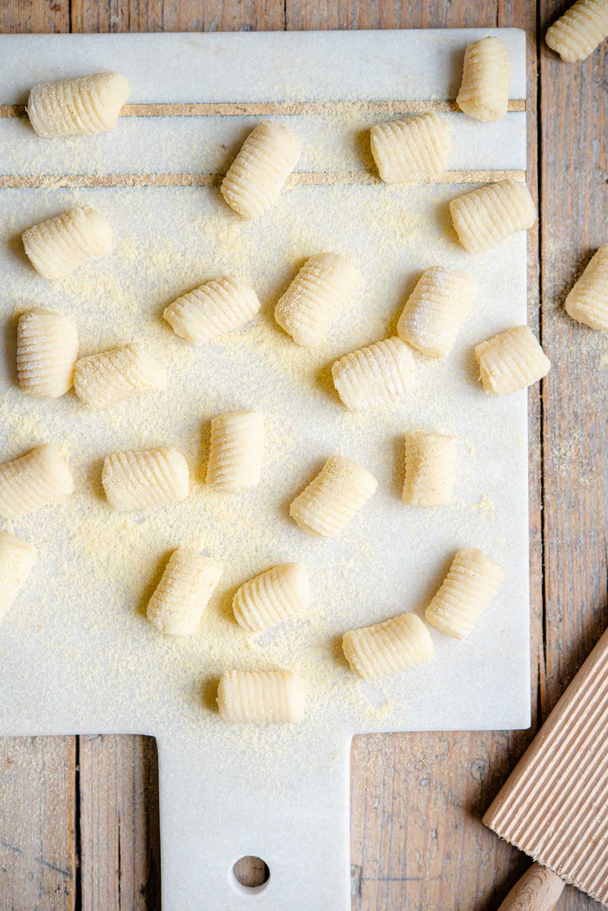 An overhead shot of potato gnocchi on a marble cutting board