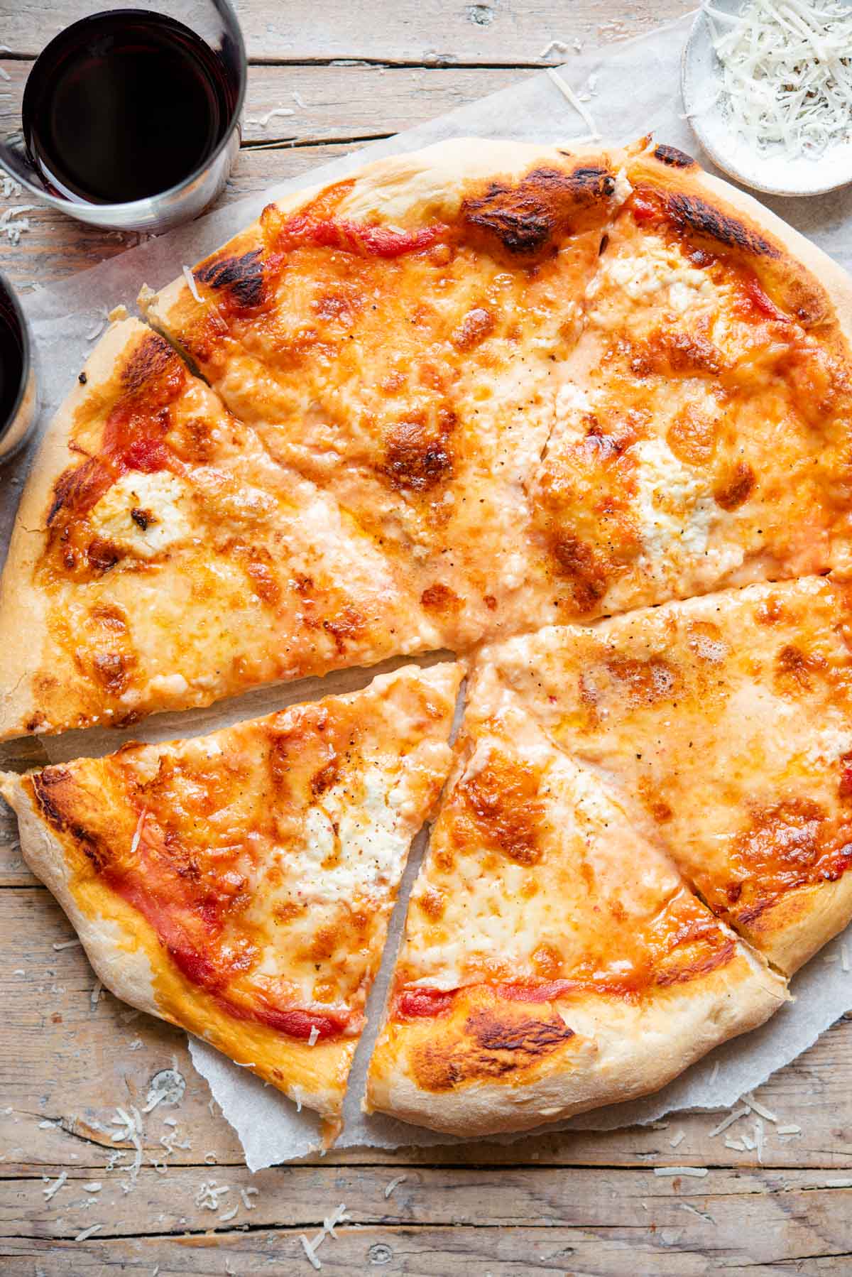 An overhead shot of a four cheese pizza cut into slices