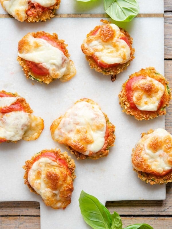 An overhead shot of zucchini pizza bites on a board