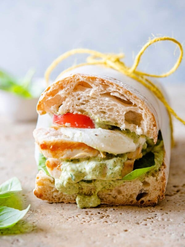 A close up of a ciabatta sandwich with chicken and pesto