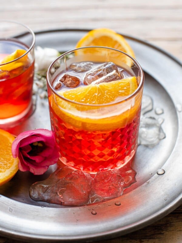 A Negroni cocktail in a glass with a slice of orange
