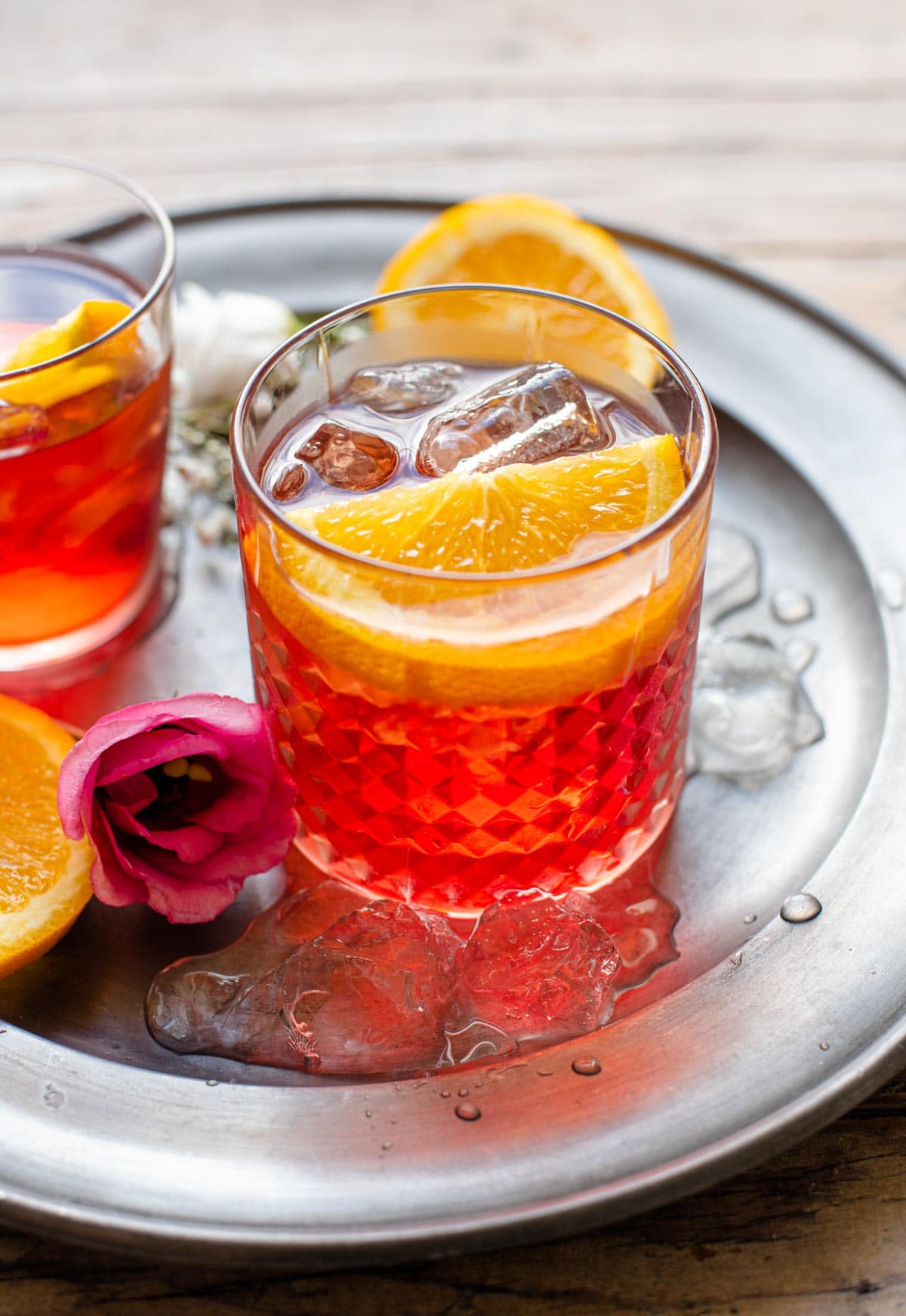 A Negroni cocktail in a glass with a slice of orange