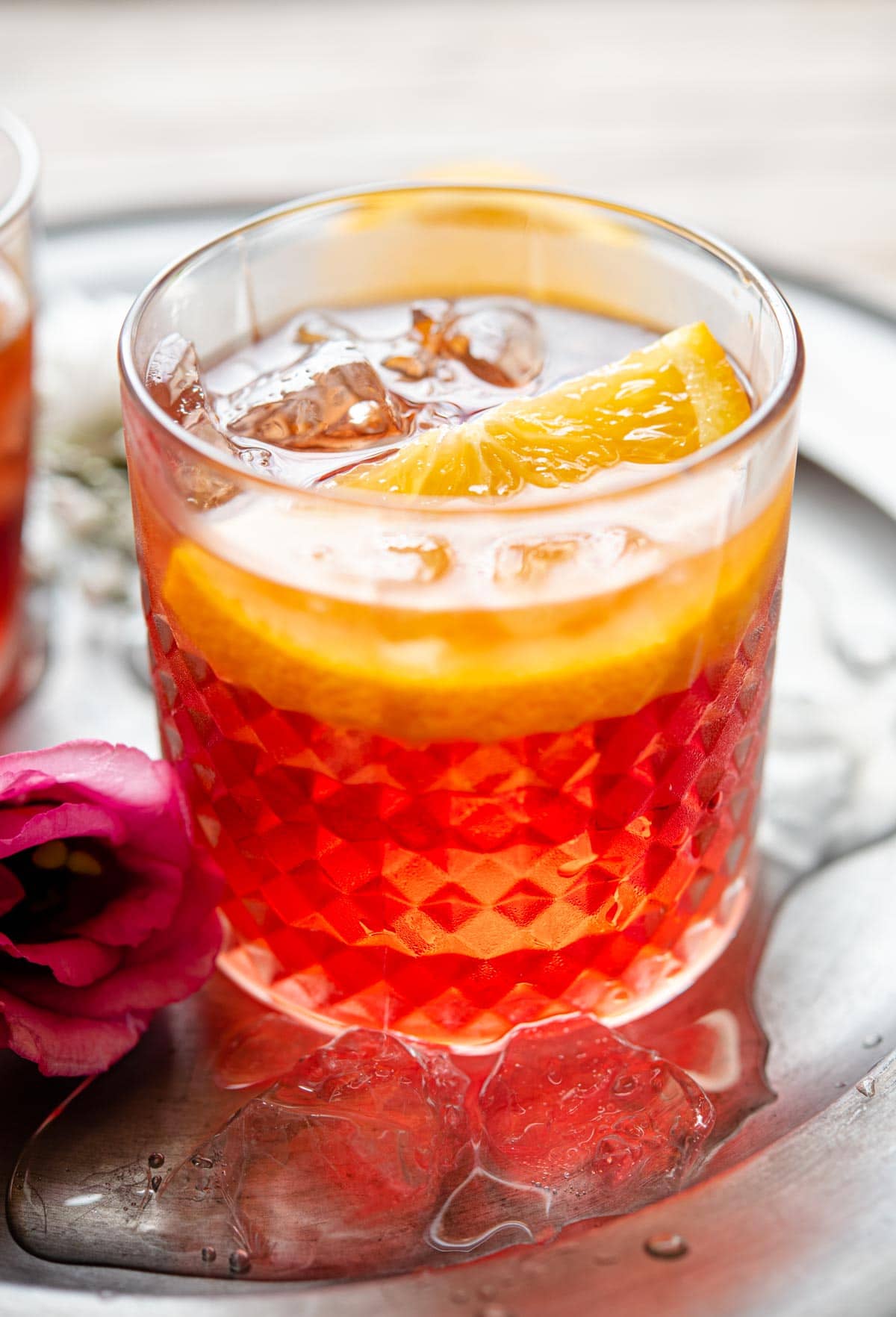 A close up of a negroni cocktail in a glass