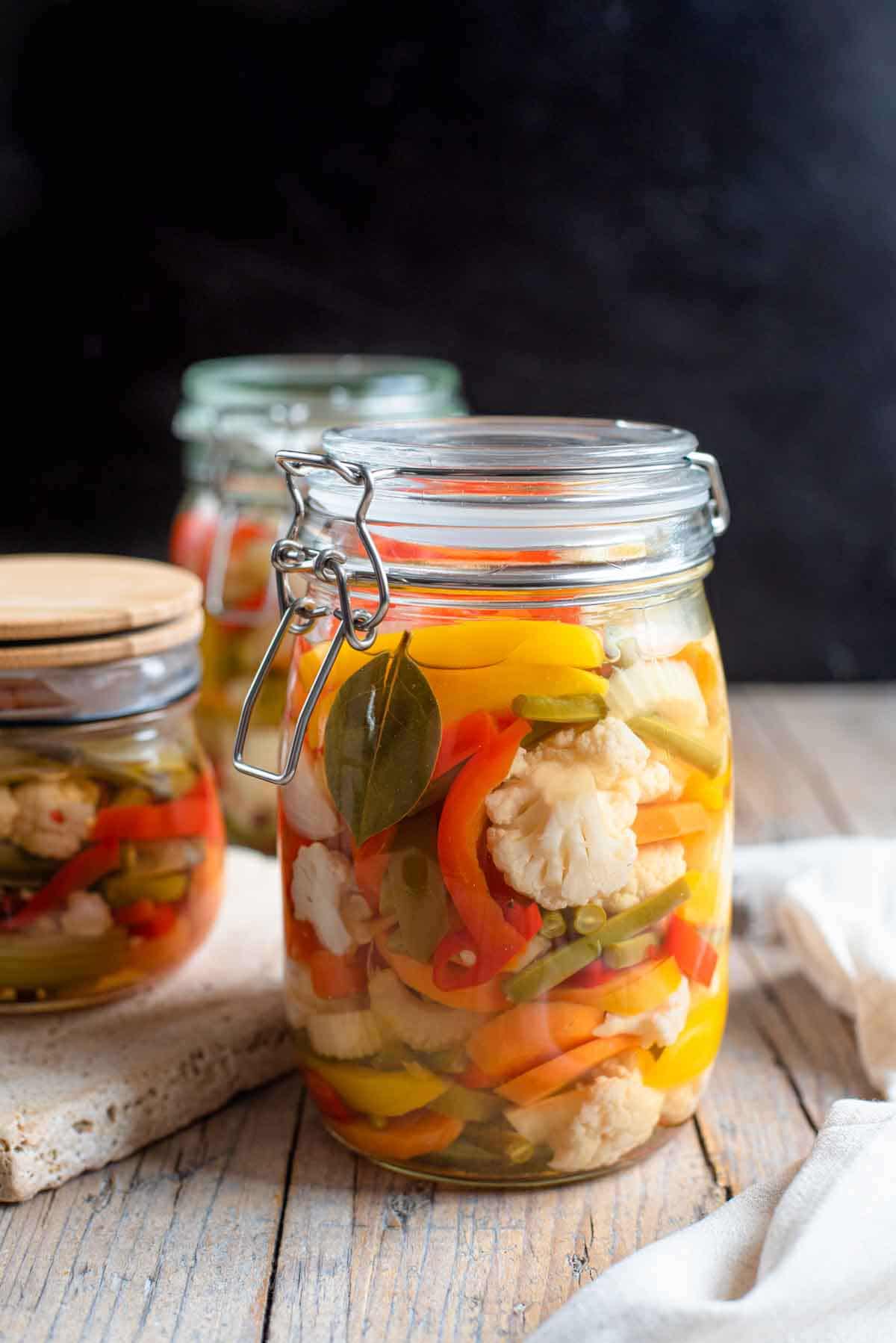 A close up of Giardiniera pickled vegetables in a glass jar