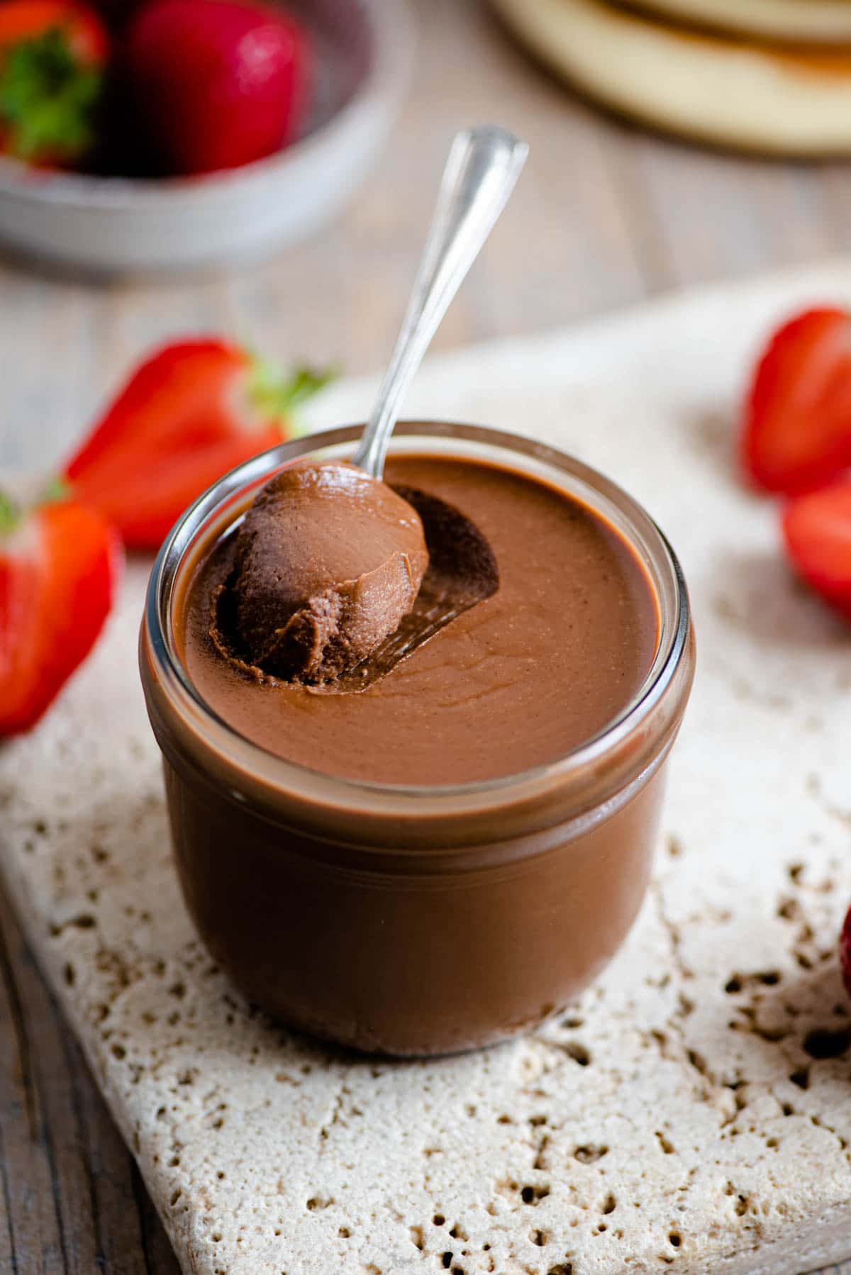 A close up of homemade nutella in a jar with a spoon