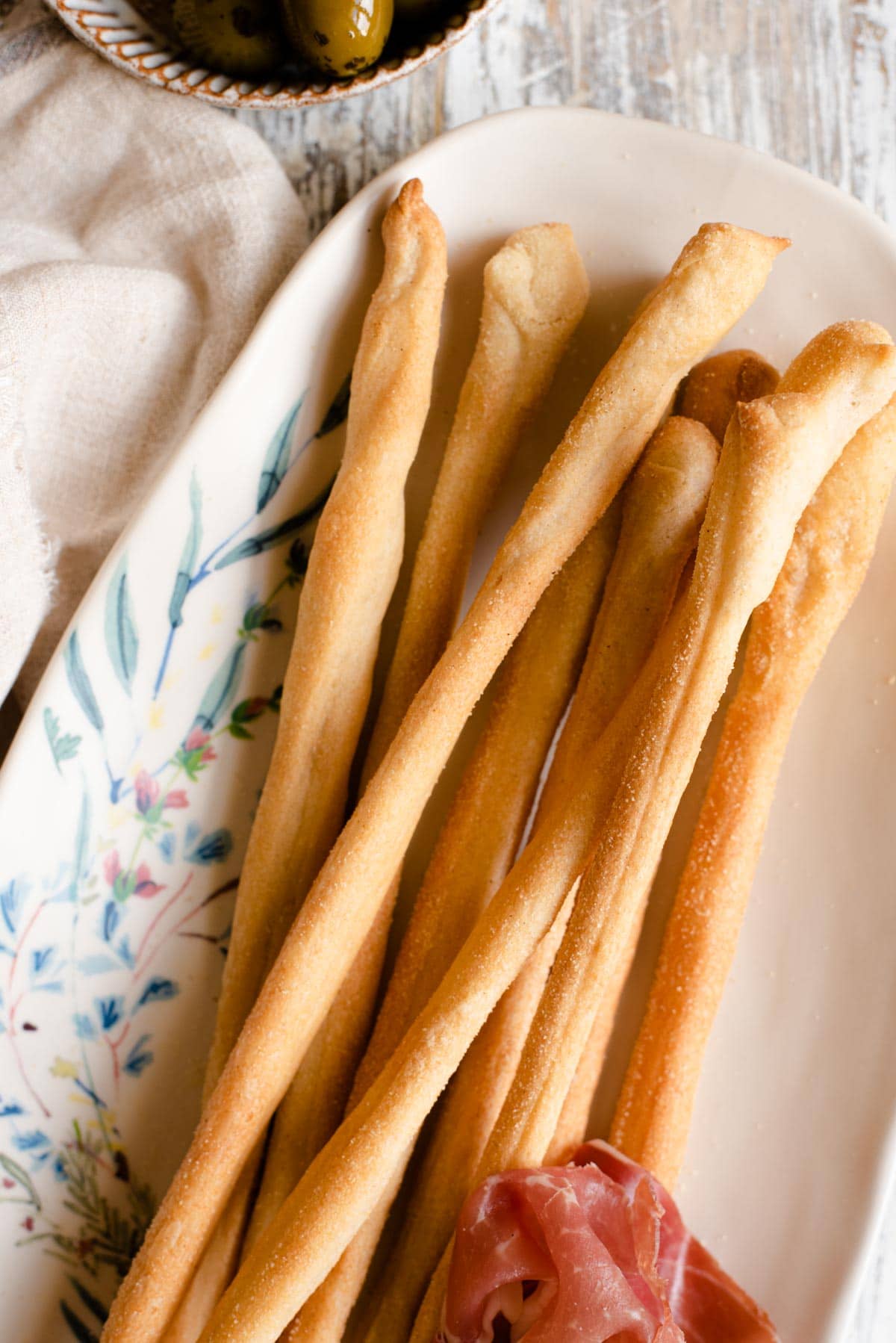 A close up of Italian Grissini breadsticks on a serving plate
