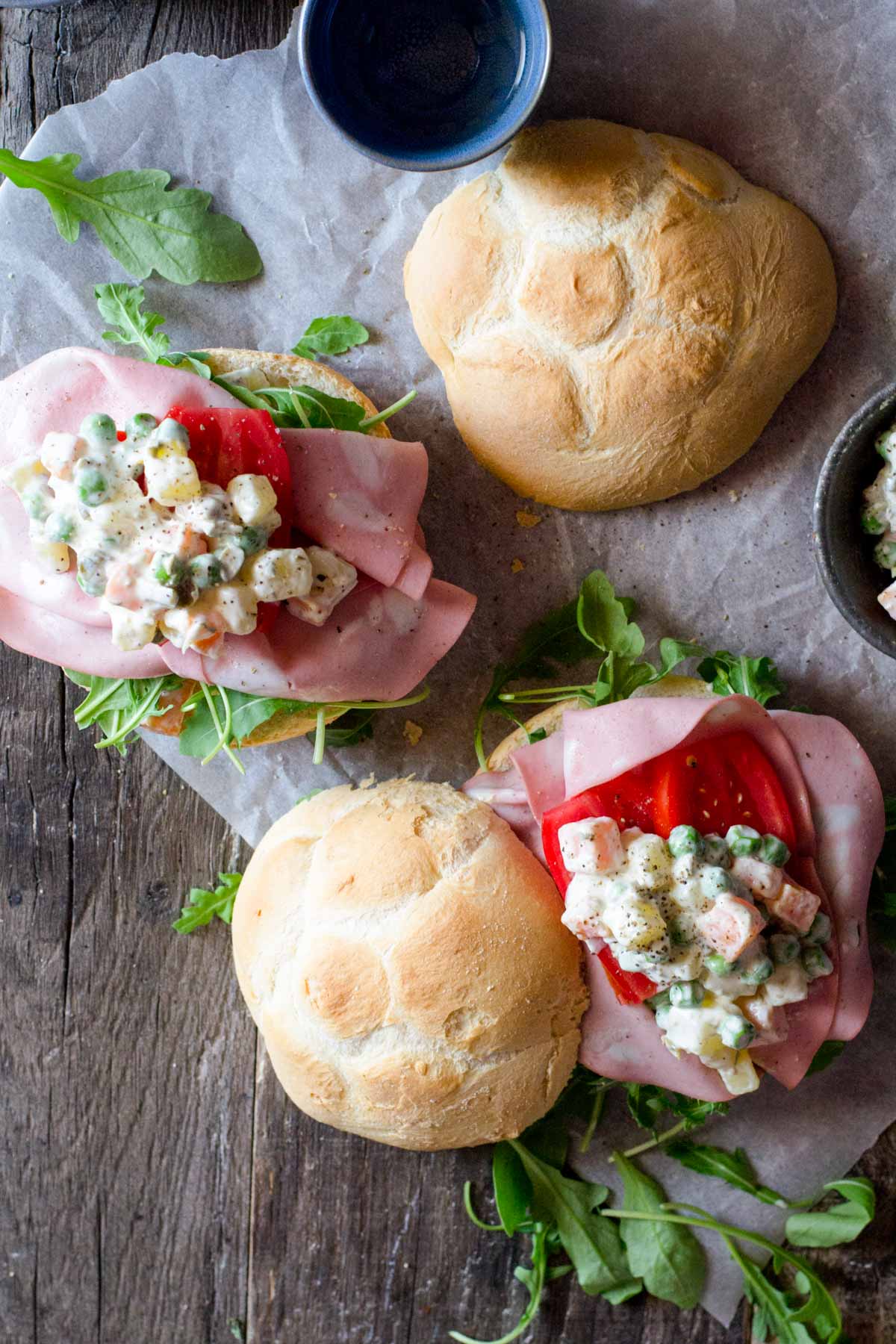 An overhead shot of Russian salad on two bread rolls