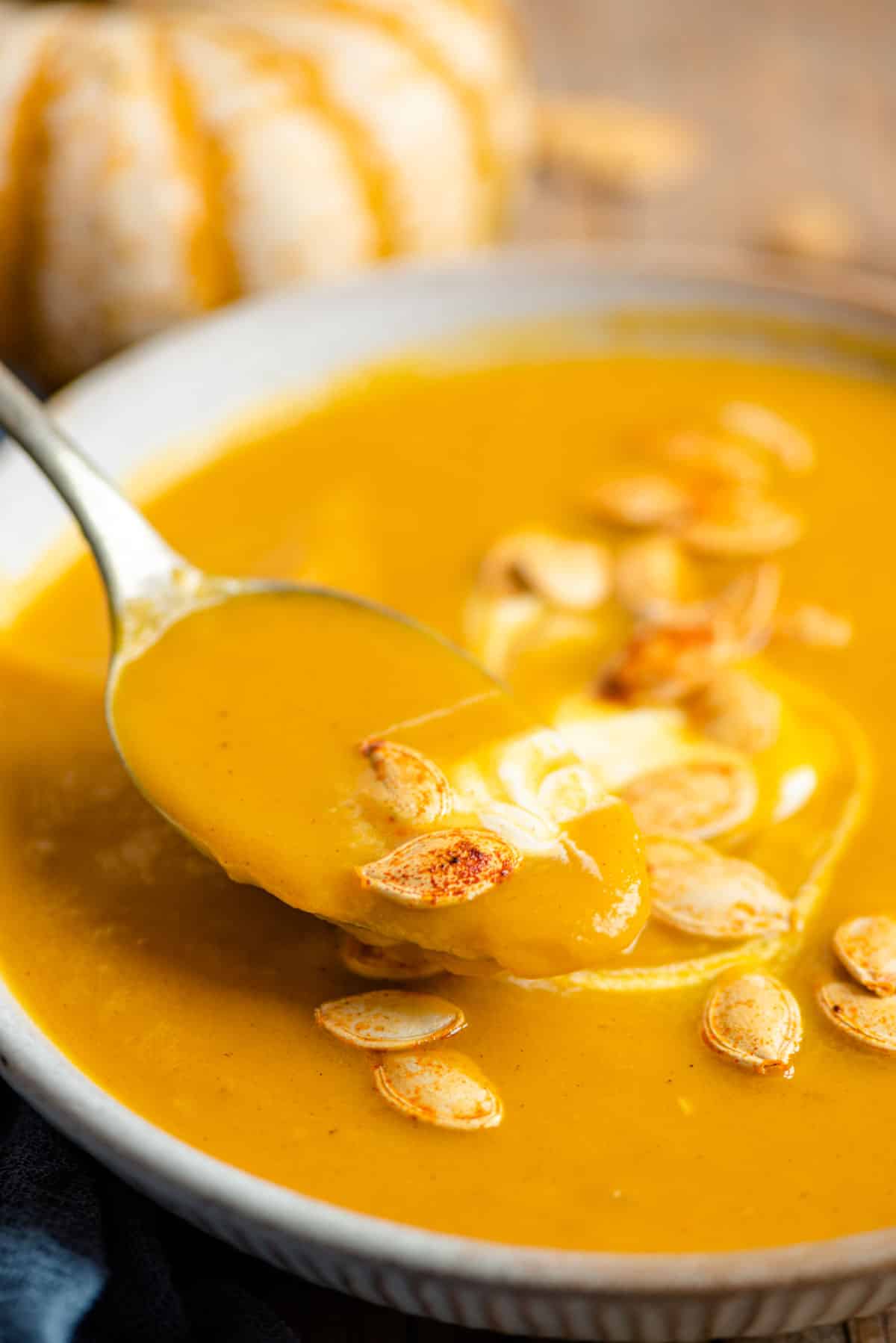 A close up of a spoonful of pumpkin soup